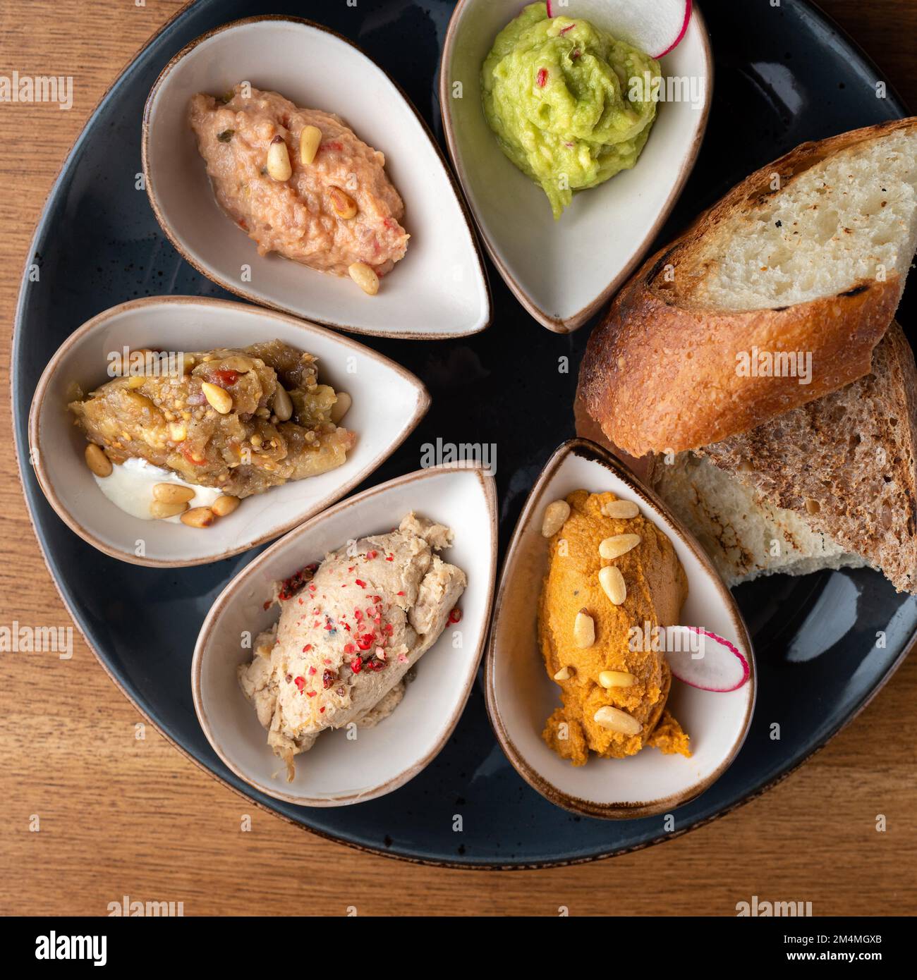 Fai uno spuntino o uno spuntino sano con Hummus, patata di coniglio, caviale di melanzane, guacamole, patata di tonno in ciotole. Cibo sano, primo piano Foto Stock