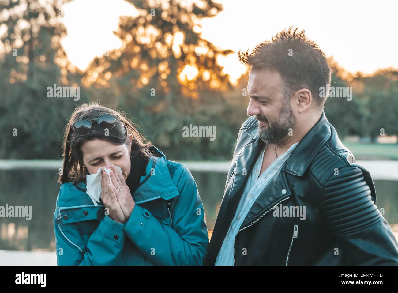Donna caucasica donna starnutisce naso a tessuto vicino da uomo con sorpresa schiena magra Foto Stock