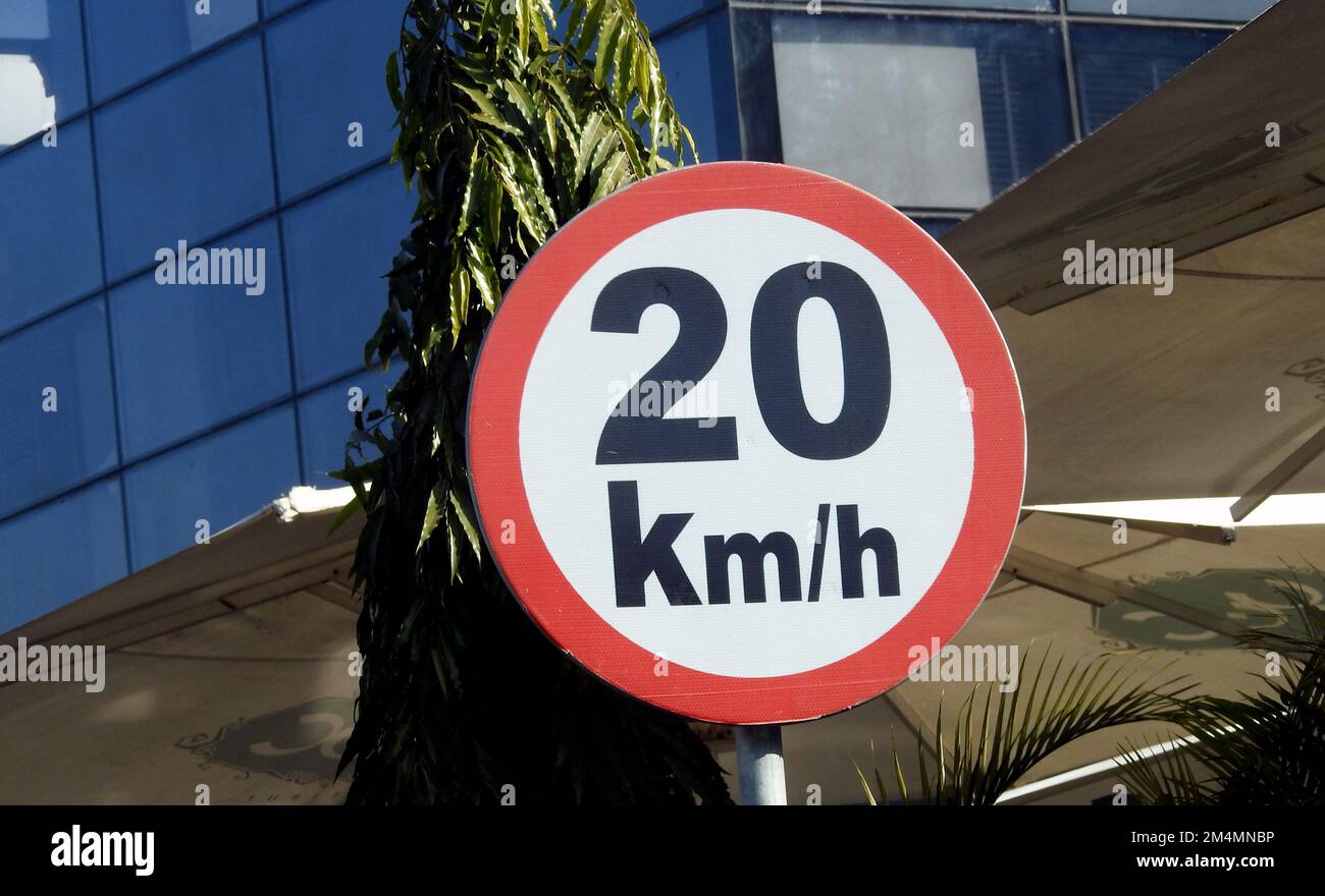 Un segnale stradale di 20 KMH venti chilometri all'ora limite di velocità nella corsia lenta vicino gateway, ristoranti e caffè, traffico prohibitorio velocità limite sig Foto Stock