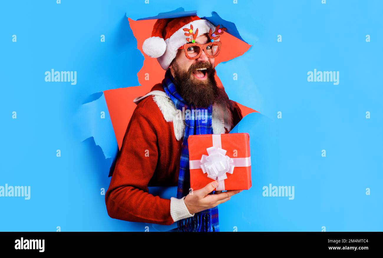 Buon Babbo Natale con la confezione regalo di Natale. Uomo bearded in occhiali da festa con Capodanno presente. Foto Stock