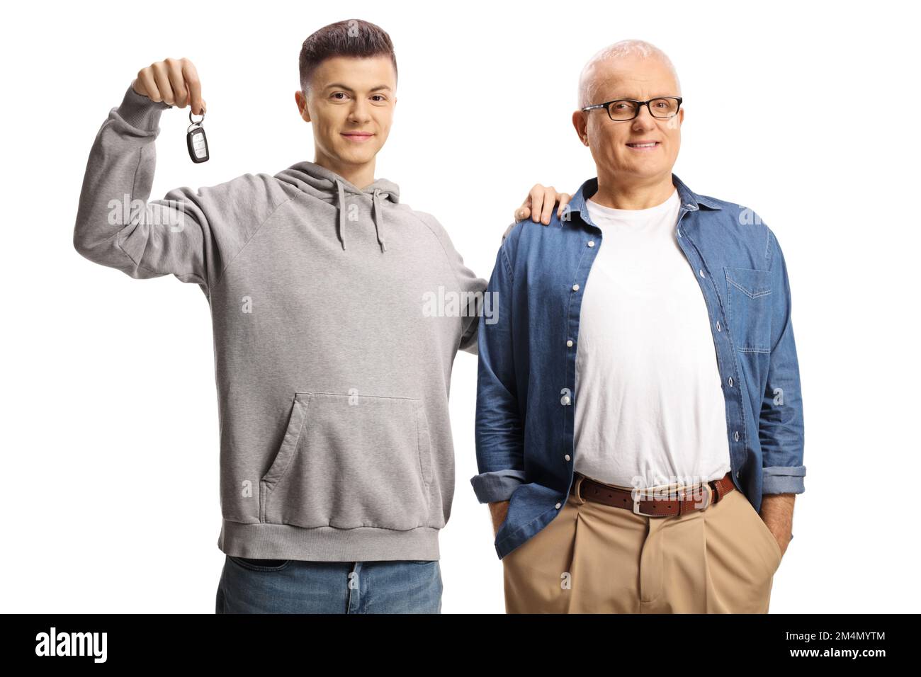 Felice e orgoglioso padre e figlio mostrando una chiave auto isolato su sfondo bianco Foto Stock