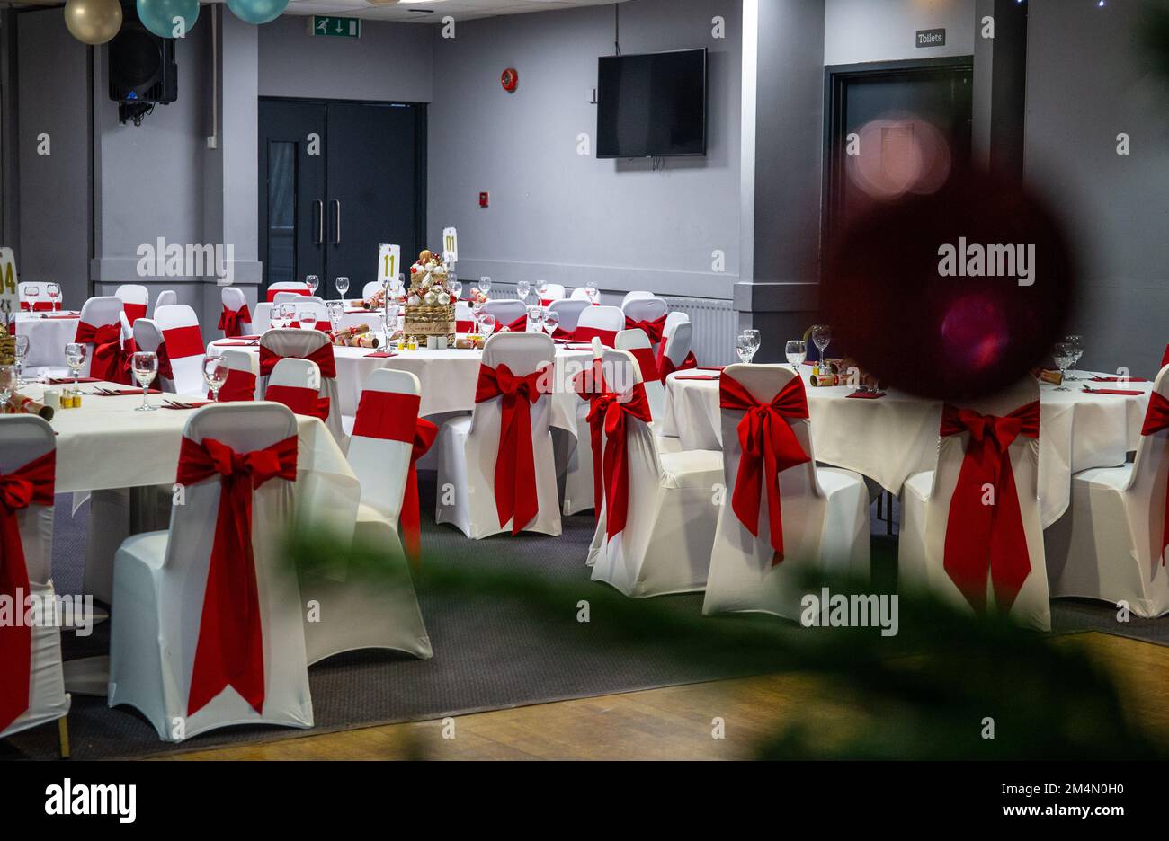 Sedie da pranzo decorate nella sala funzioni allestite per feste di Natale nel Regno Unito Foto Stock