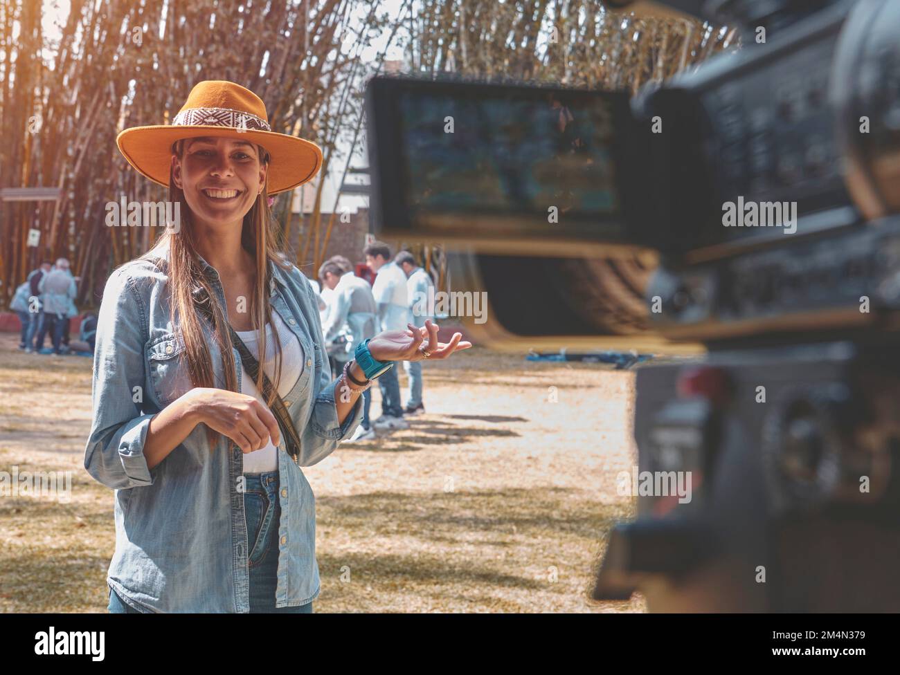 Foto esterna di giovane bella donna vlogging, felice sorridente giovane vlogger posando sulla macchina fotografica. Foto Stock