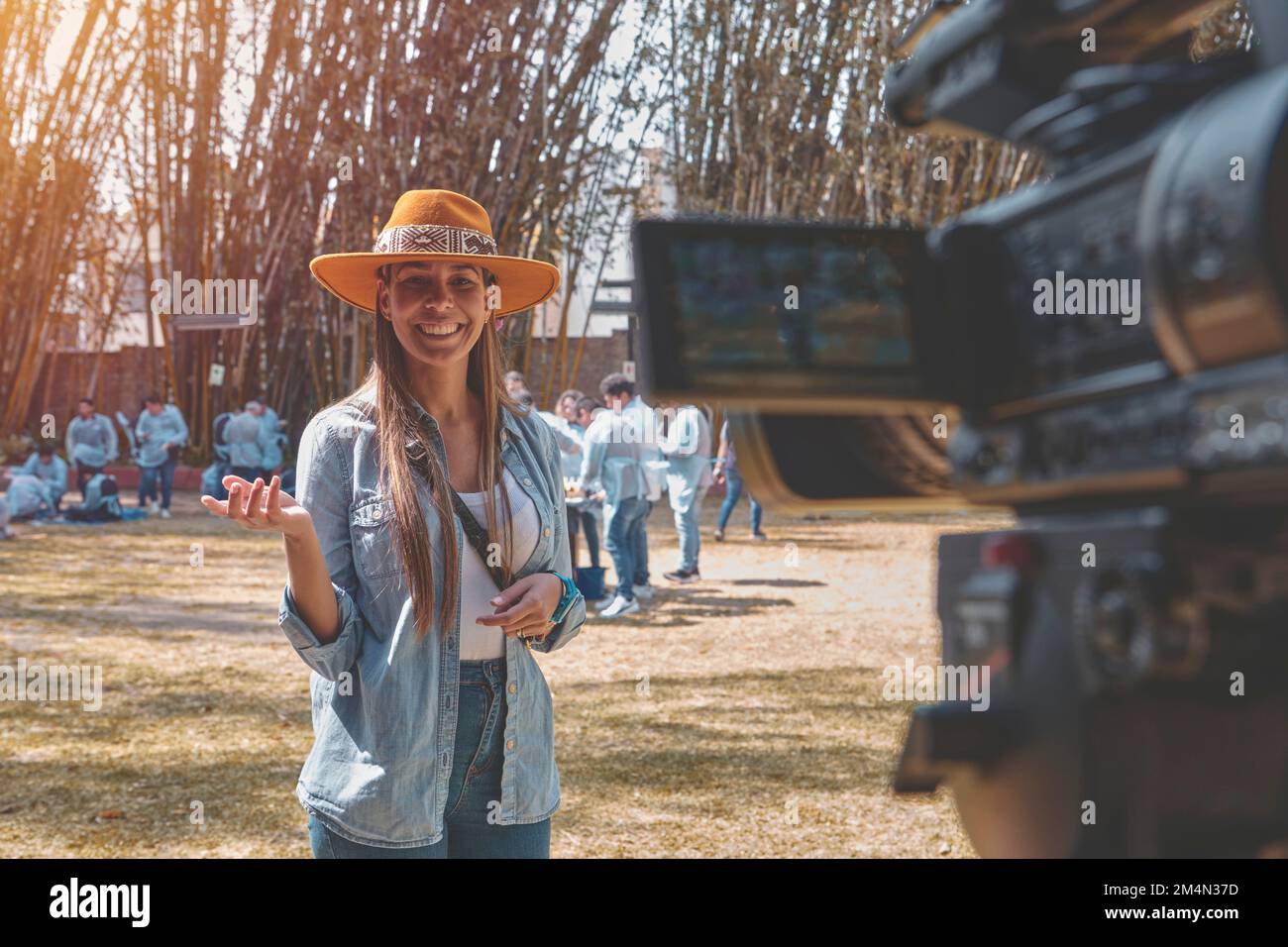 Foto esterna di giovane bella donna vlogging, felice sorridente giovane vlogger posando sulla macchina fotografica. Foto Stock