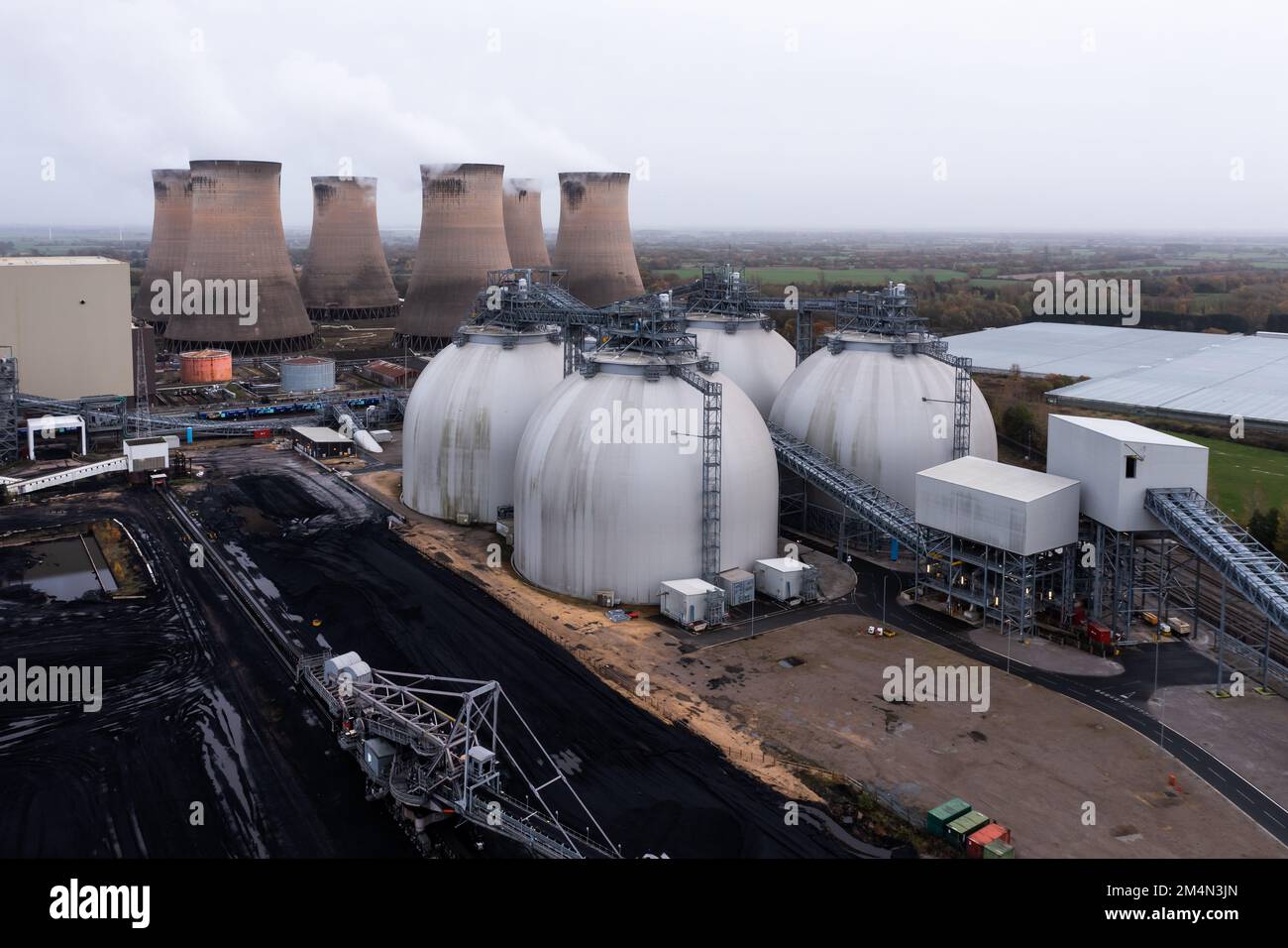 Grandi serbatoi di stoccaggio di biocarburanti o contenitori in una centrale elettrica alimentata a carbone piena di biomassa rinnovabile per bruciare invece di carbone o ridurre il carico di carbonio Foto Stock