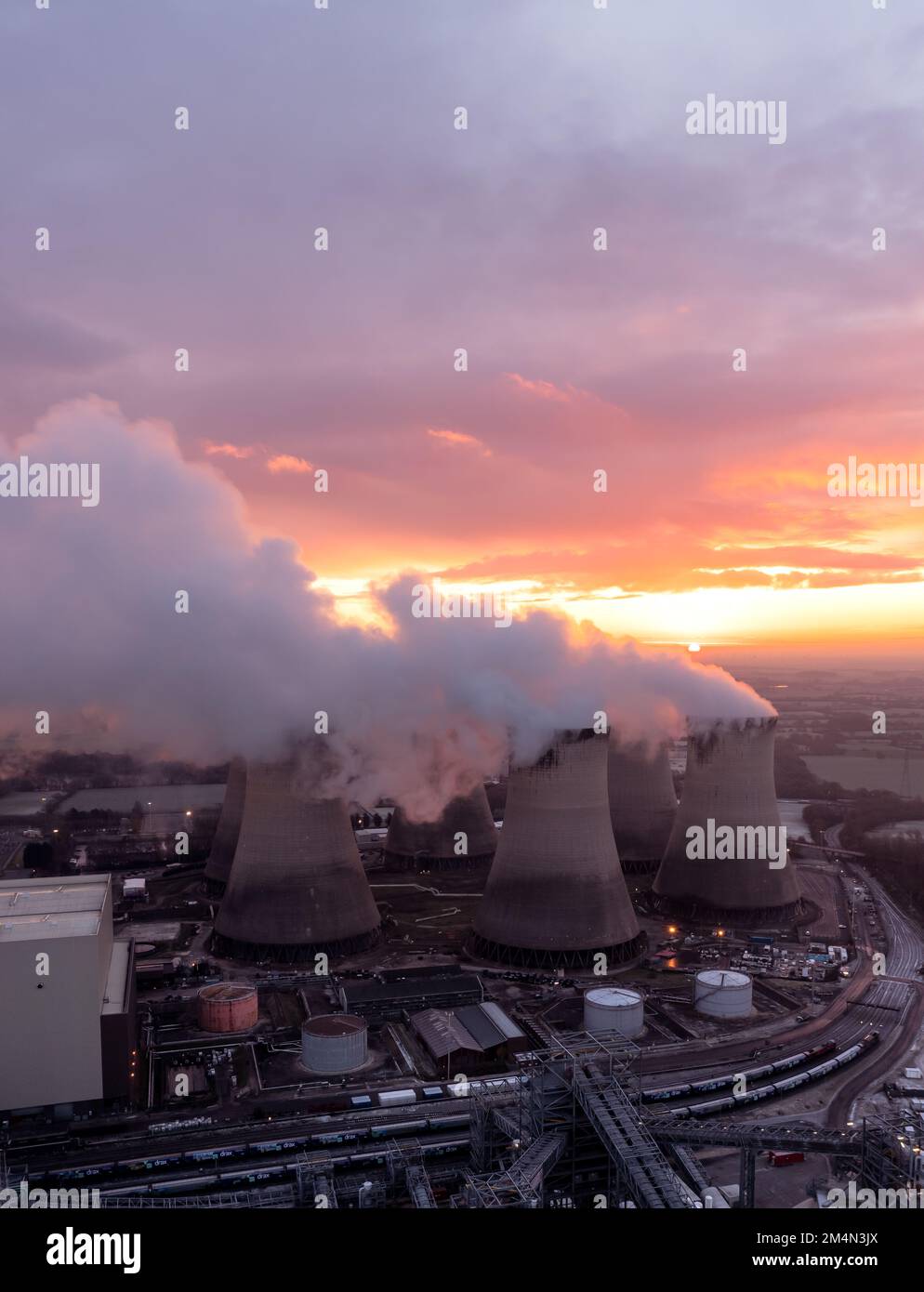 Vista aerea delle torri di raffreddamento delle centrali a carbone sporco che inquinano l'atmosfera con emissioni di anidride carbonica al tramonto Foto Stock