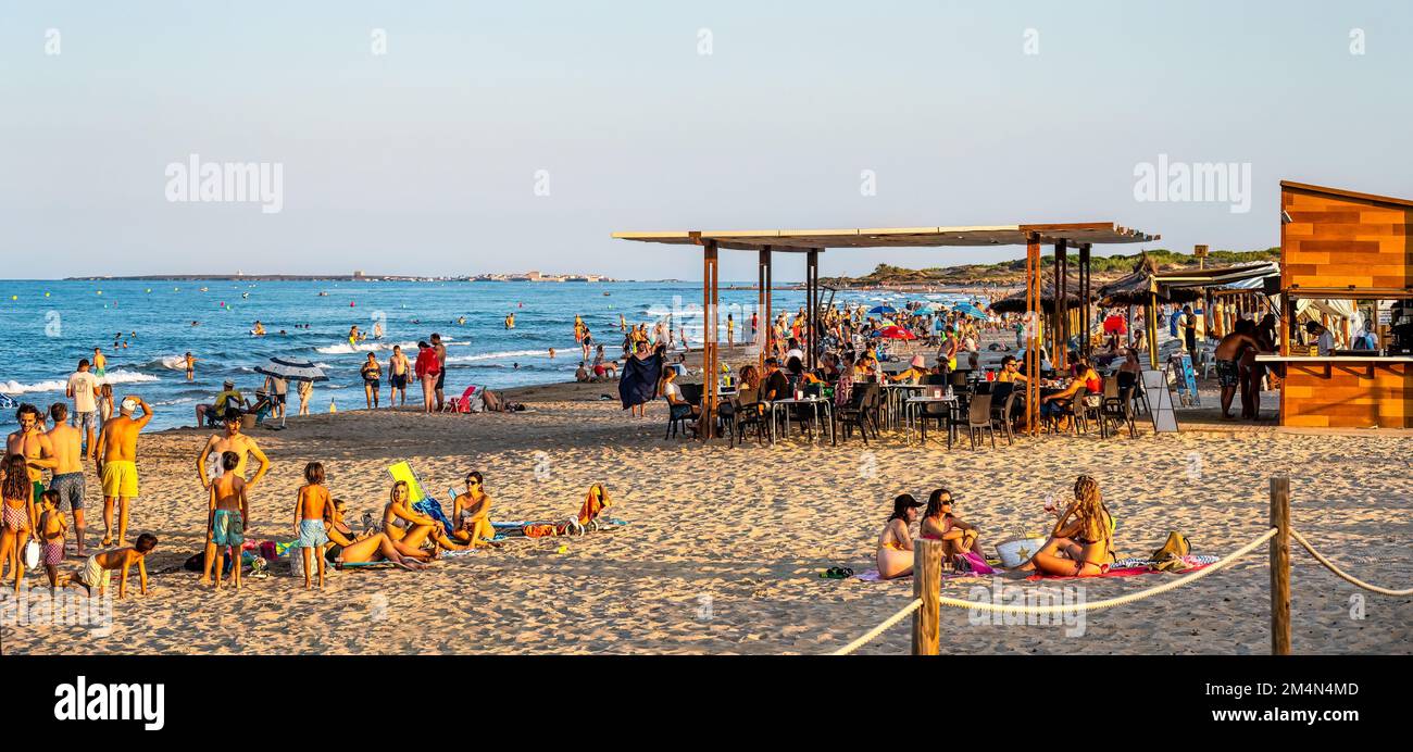 Elche spiaggia. Un grande gruppo di persone o turisti che si godono la luce del tramonto d'oro. Foto Stock