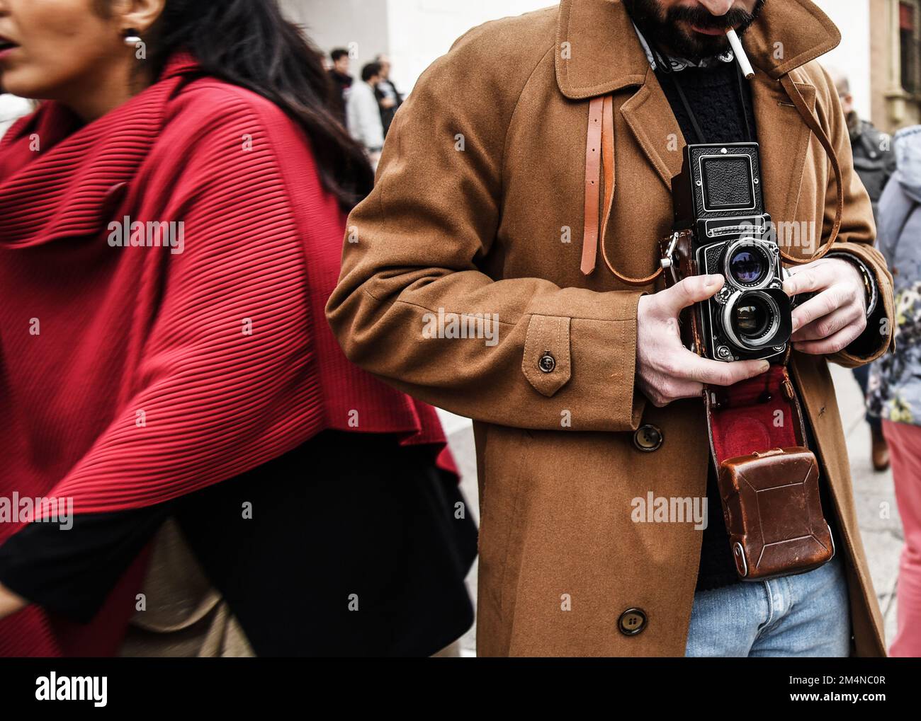 Hipster ragazzo con la fotocamera d'epoca fotografando le persone nel Città - fotogiornalista con una famosa fotocamera retrò che scatta foto nella folla durante str Foto Stock