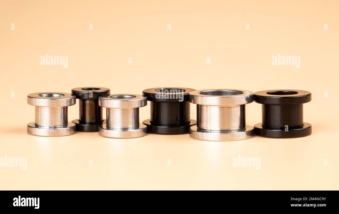 piercing alle orecchie in tunnel bianco e nero. Foto Stock