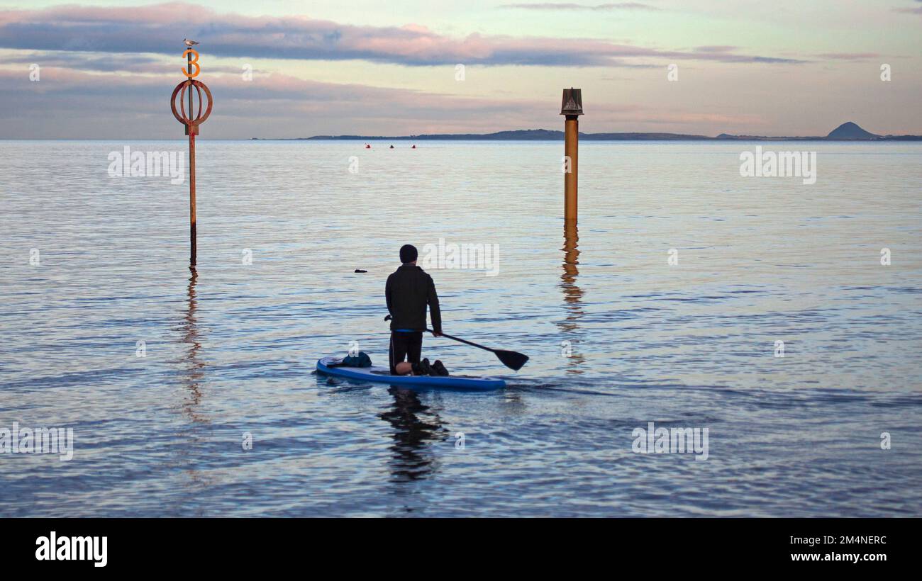 Portobello, Edimburgo, Scozia, Regno Unito. 22nd dicembre 2022. Clima sereno e nuvoloso che rende la superficie liscia sul Firth of Forth per coloro che si occupano di sport acquatici. Temperatura a fredda 6 gradi centigradi. Un solo pedalofano maschile si esercita sulla superficie piana e tranquilla. Credit: ArchWhite/alamy live news. Foto Stock