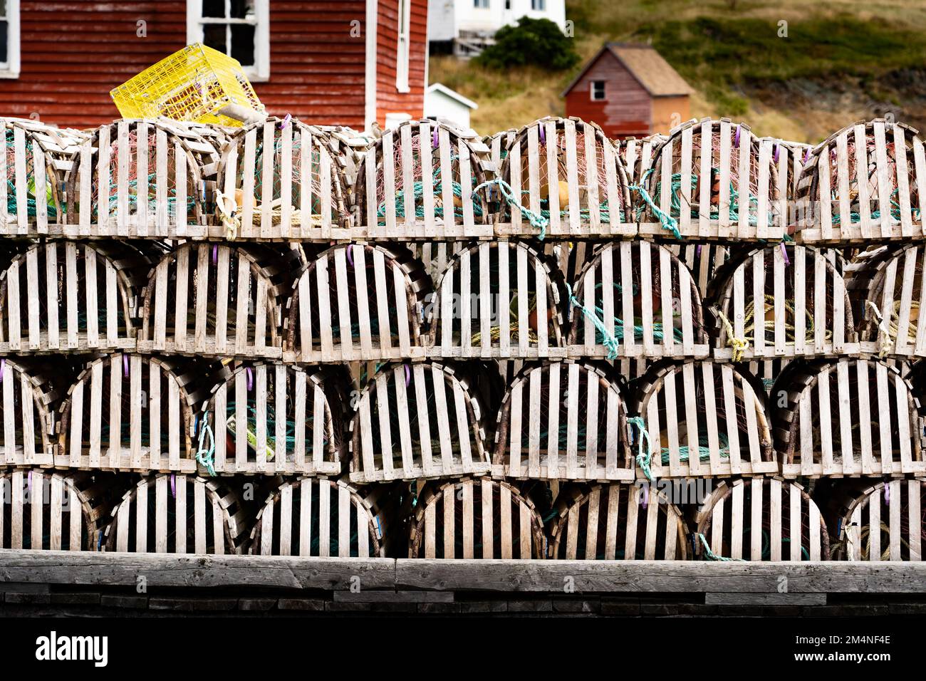 Trappole di aragosta di legno impilate su un molo vicino al piccolo villaggio di pescatori di Trinity Terranova Canada. Foto Stock