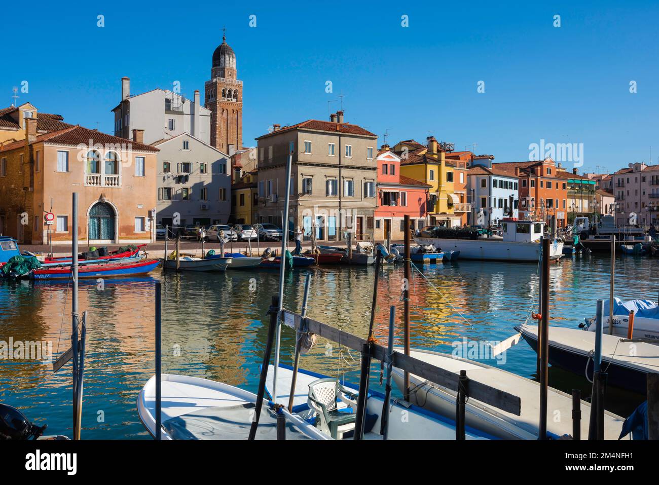 Laguna di Venezia Chioggia, vista in estate di edifici storici e barche da pesca ormeggiate nel canale Lombardo di Chioggia, comune di Venezia Foto Stock