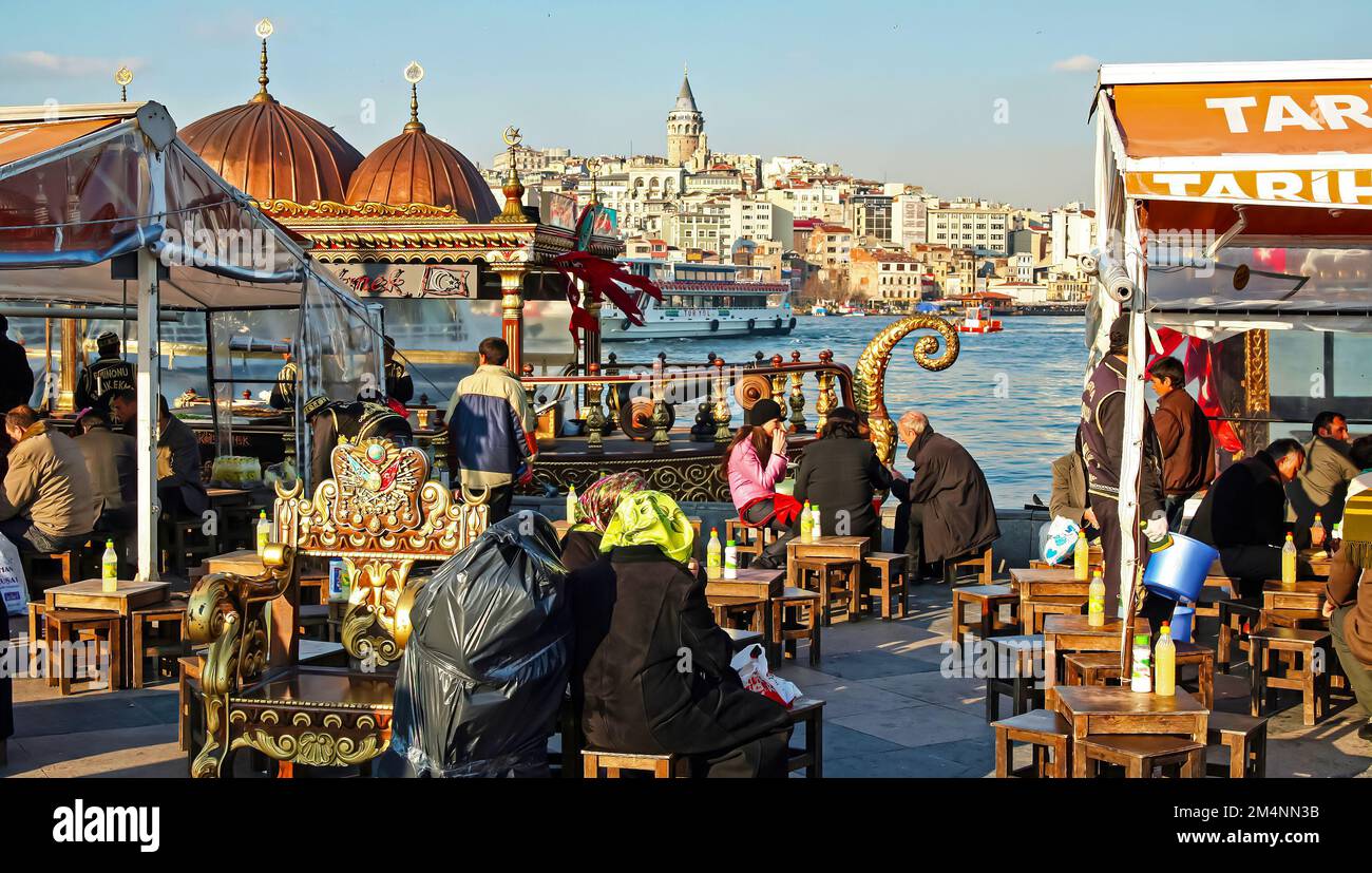 Istanbul (Corno d'Oro), Turchia - Febbraio 24. Giorno 2017: Tipici caffè turchi lungo la strada, skyline del quartiere di galata sfondo in primavera Foto Stock