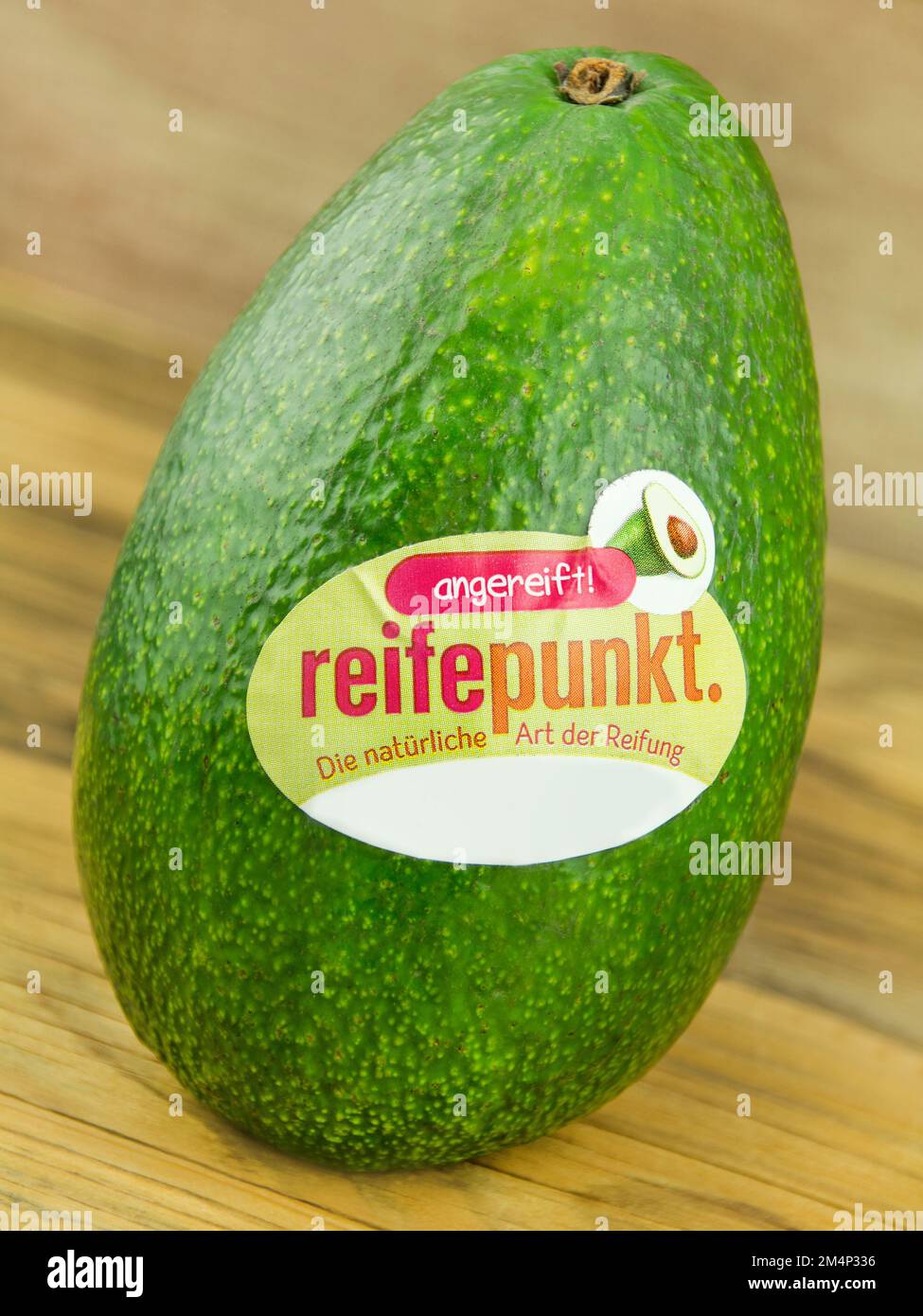 Amburgo, Germania - Dicembre 6 2022: Avocado und Label mit Reifepunkt auf Holz - Avocado ed etichetta con punto di maturazione su legno Foto Stock