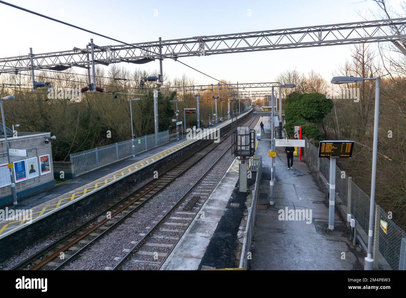 La piattaforma e il binario ferroviario in Sawbridgeworth stazione ferroviaria a terra con tavole di partenza illuminate Foto Stock