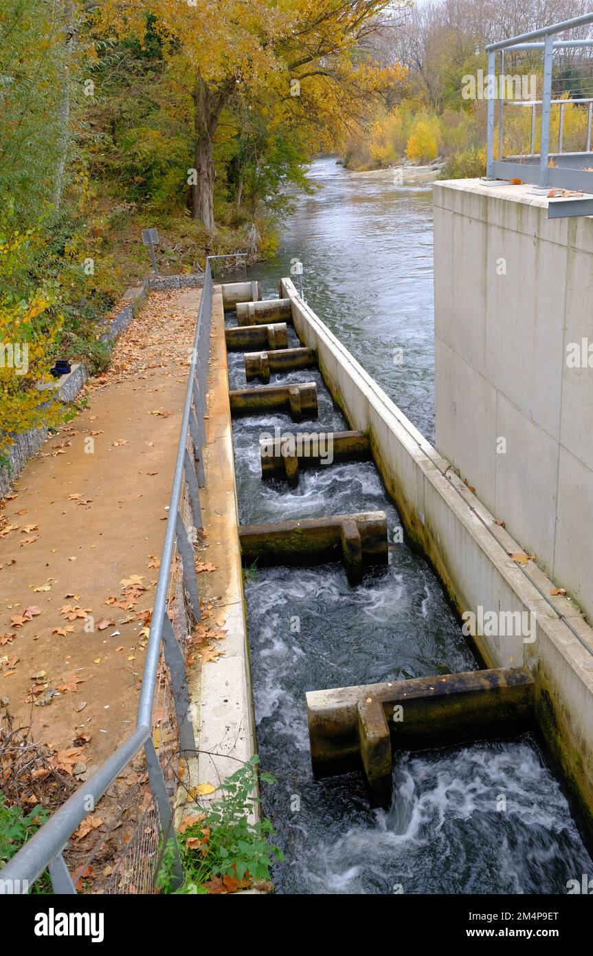 Carca Aude France 12.8.22 Scala di pesca. Acqua fluente veloce attraverso un canale di calcestruzzo. I tubi a T causano un rallentamento del flusso. Grande alberato fiume b Foto Stock