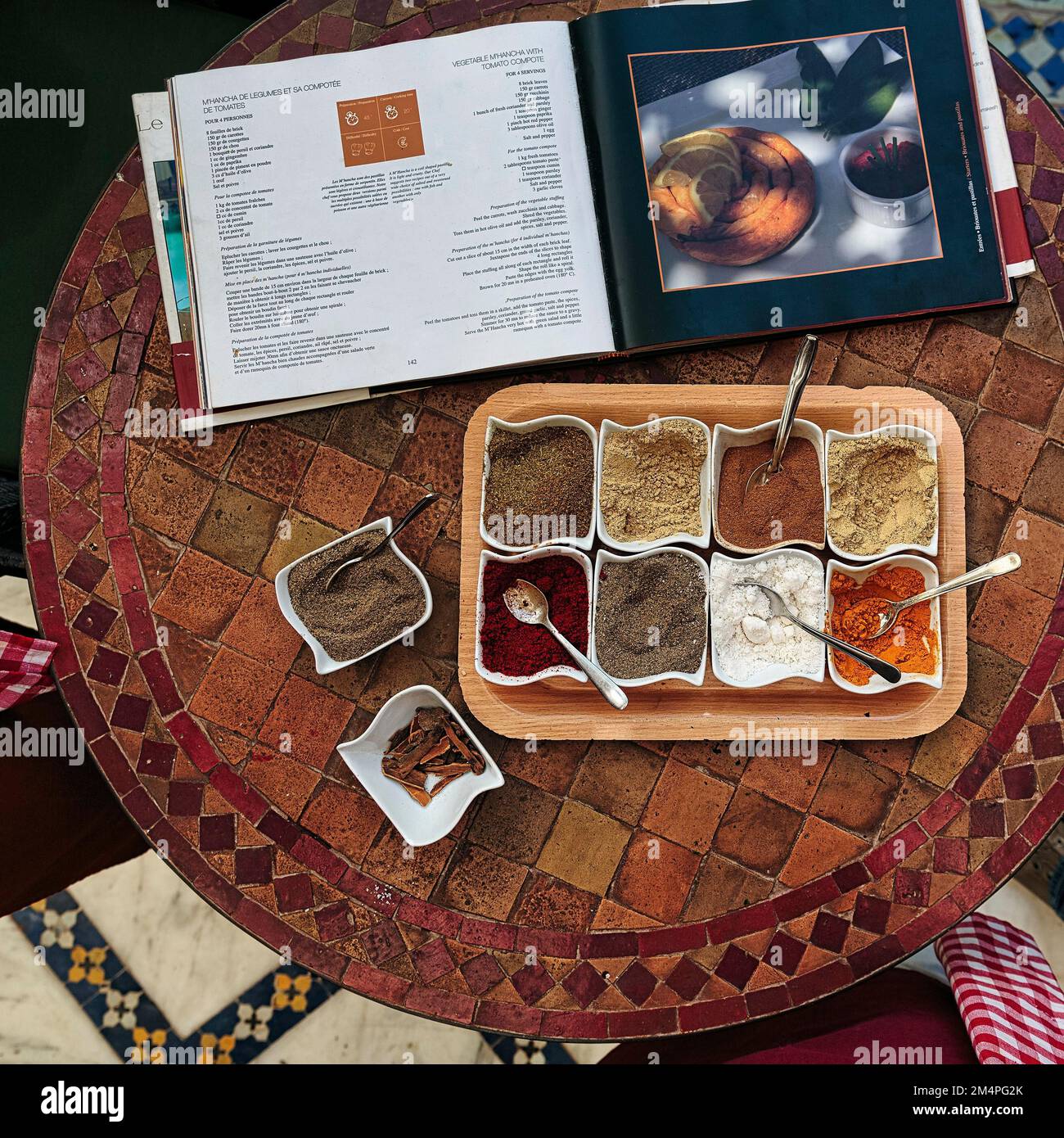 Spezie varie, miscele di spezie in ciotole, libro di cucina con specialità marocchine, corso di cucina, Marrakech, Marocco Foto Stock