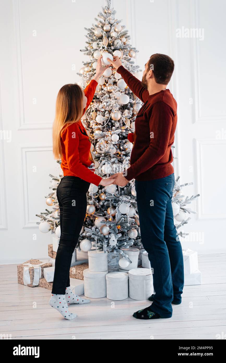 Vacanze invernali e concetto di persone - coppia felice decorazione albero di Natale a casa Foto Stock