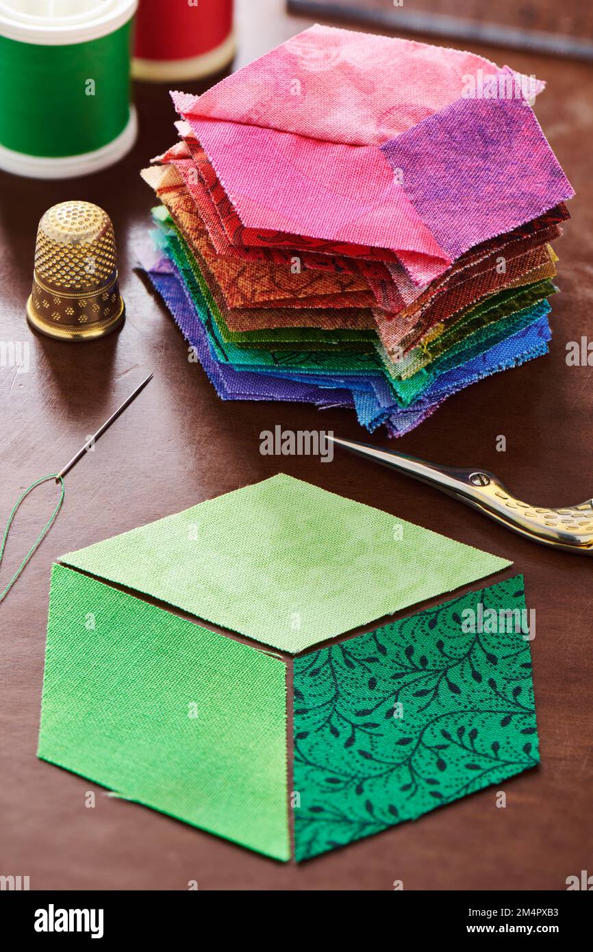 Pila di diamanti cuciti come un cubo e tre diamanti, che saranno cuciti sotto forma di un cubo, che costituirà la base del futuro patchwork Foto Stock