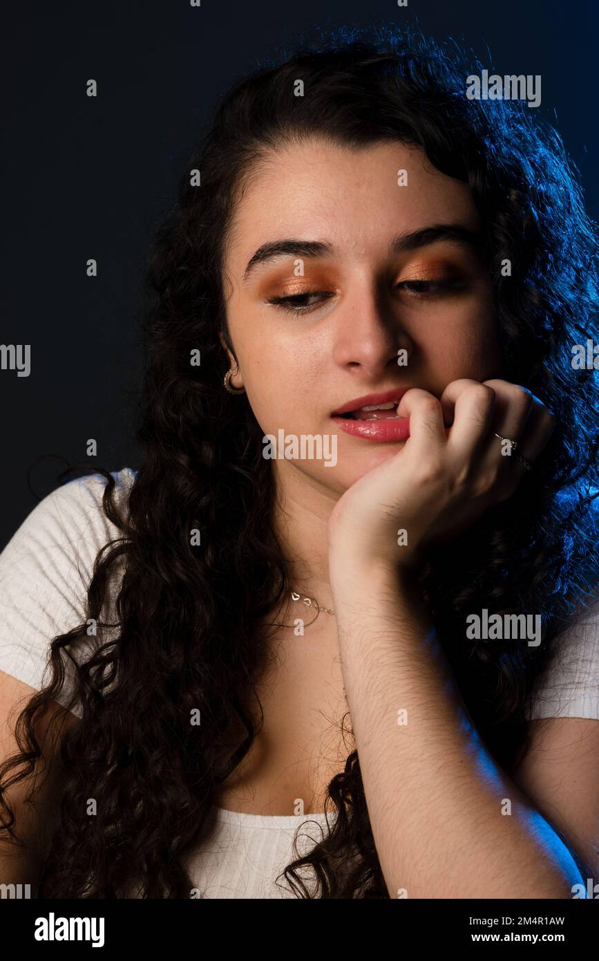 Allegra giovane bella donna con una mano sulla bocca. Su sfondo grigio. Foto Stock