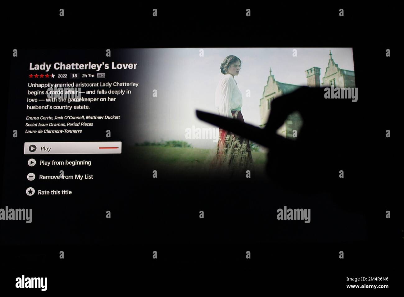 App Netflix su uno schermo tv che mette in risalto l'amante di Lady Chatterley con l'ombra di qualcuno che tiene un telecomando Foto Stock