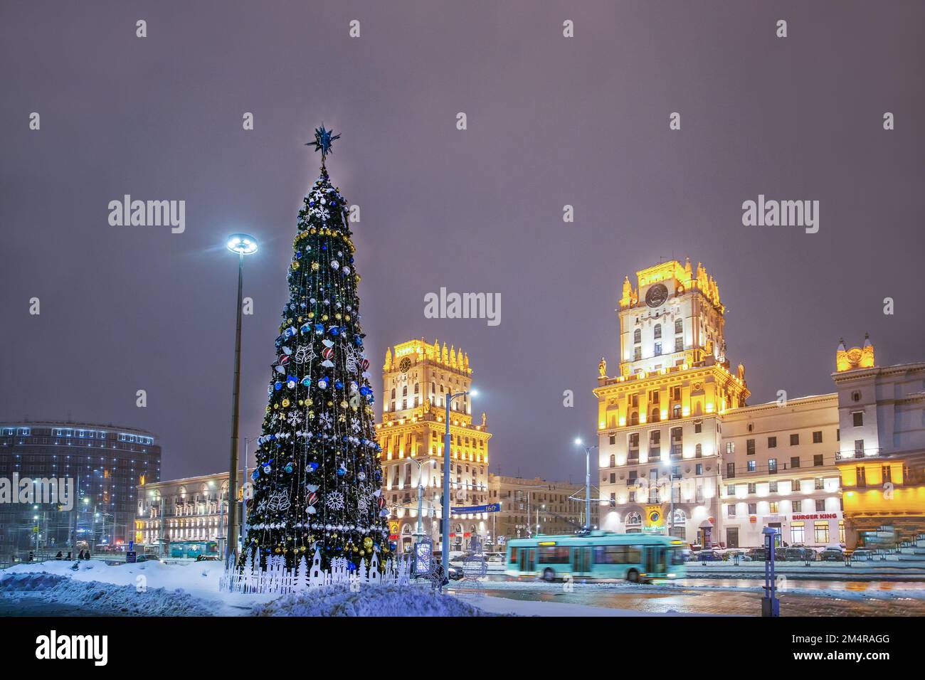 Albero di Natale a Minsk Bielorussia sulla piazza accanto alla stazione ferroviaria di mattina di dicembre. Caduta di neve - Una favola invernale - la neve sta cadendo! Foto Stock