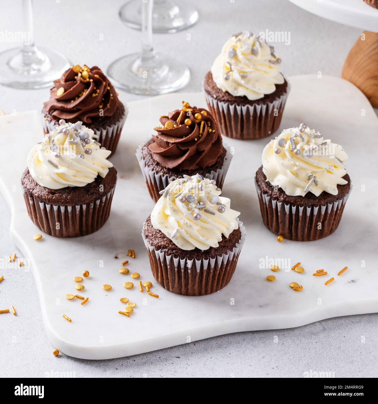 Cupcake festive con spolverini serviti con champagne per la festa di Capodanno, dessert idea Foto Stock