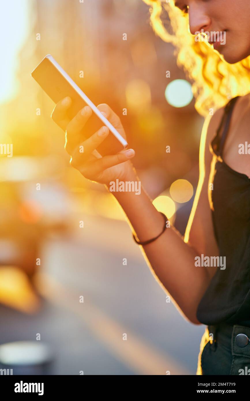 Shes collegato alla città. una giovane donna attraente che invia un testo mentre cammina per la città. Foto Stock