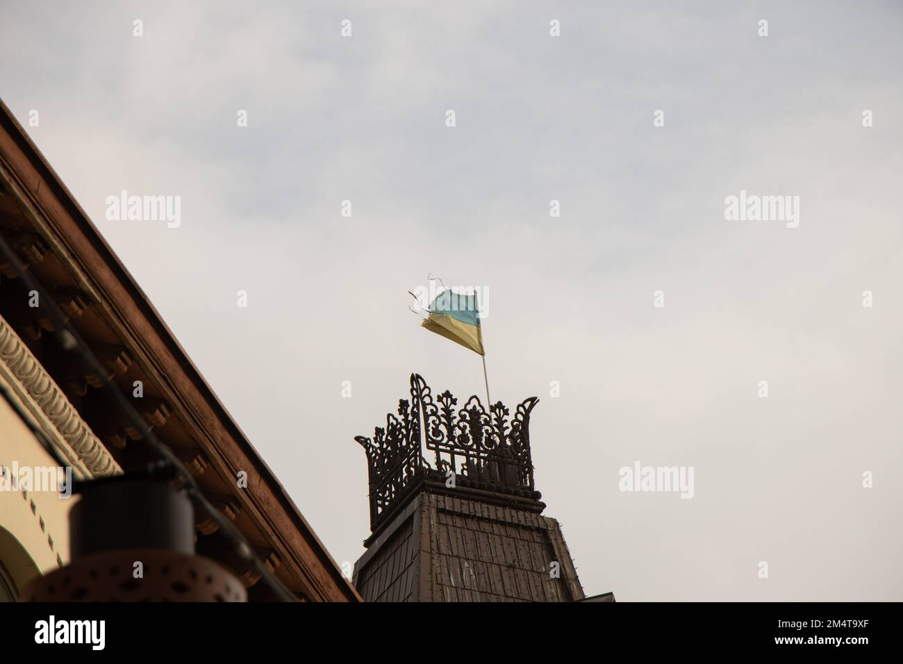vecchia bandiera strappata di ucraina giallo-blu sui tetti di una casa nel centro della città di dnipro in ucraina Foto Stock