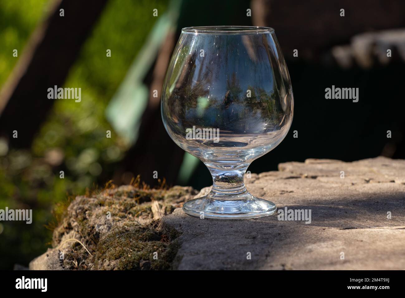 un calice di vetro trasparente vuoto si trova a terra Foto Stock