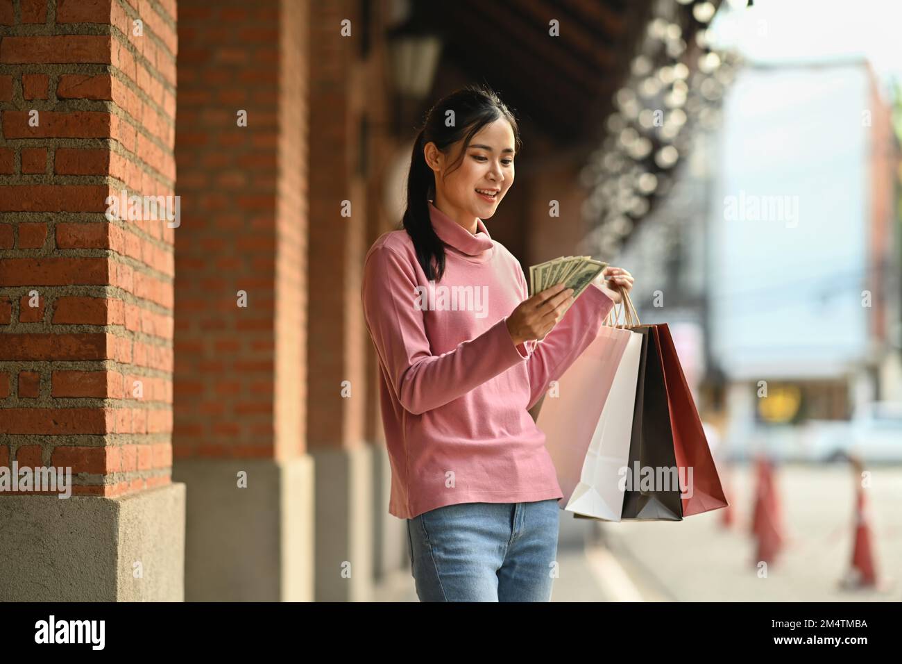 Donna asiatica felice in possesso di borse da shopping e fan di soldi.  Shopping, moda e vacanza vacanza concetto di stile di vita Foto stock -  Alamy