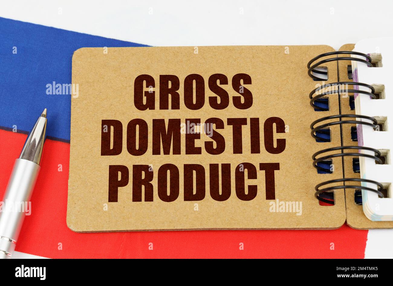 Concetto di business e tecnologia. Sulla bandiera della Russia si trova una penna e un blocco note con l'iscrizione - PRODOTTO INTERNO LORDO Foto Stock