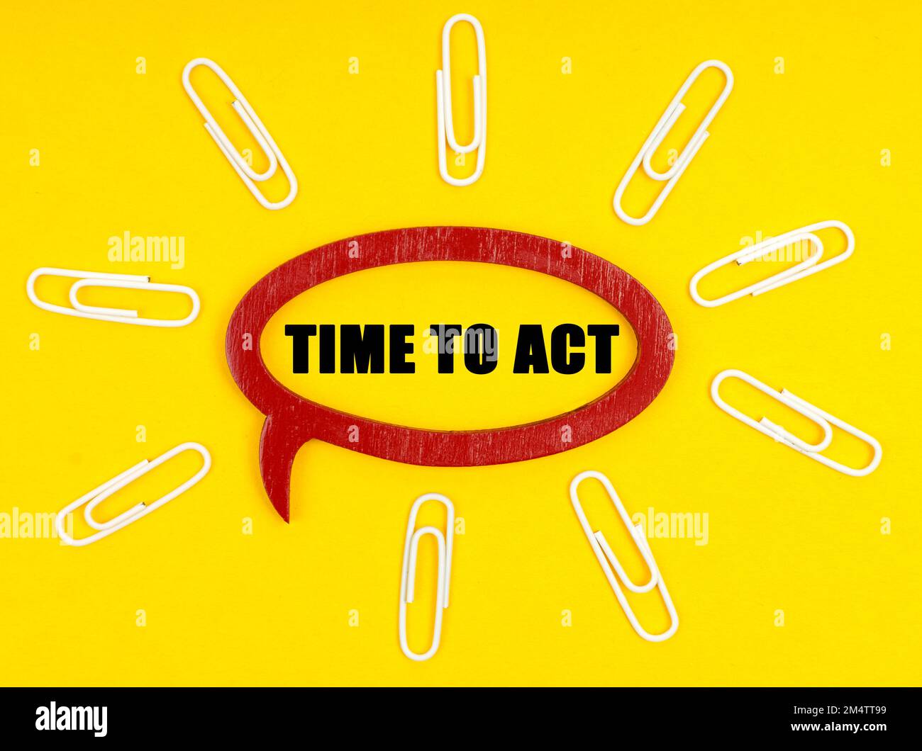 Business e concetto di economia. Sulla superficie gialla sono presenti delle graffette e una piastra all'interno della quale è riportata l'iscrizione "TIME TO ACT" (TEMPO DI AZIONE) Foto Stock