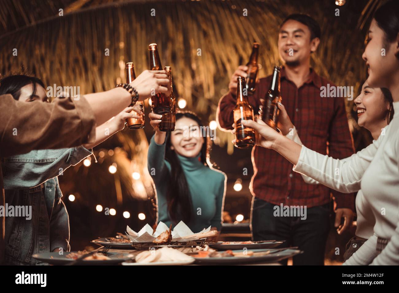 gruppo di persone che festeggia all'aperto in giardino bevendo birra Foto Stock