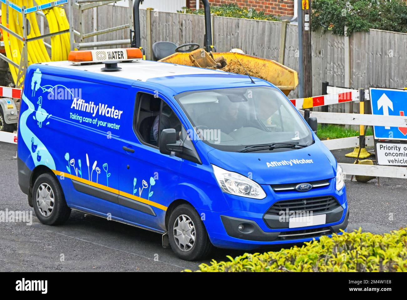 Vista laterale e frontale Affinity Water supply Company business Ford van in strada residenziale guida passato gas principale sostituzione strada lavori Essex Inghilterra UK Foto Stock