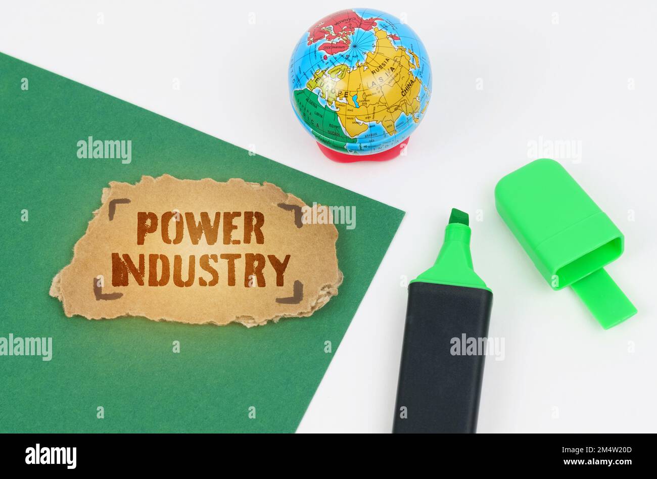 Concetto ecologico ed industriale. Sul tavolo c'è un globo e un pennarello, su sfondo verde c'è un cartone con l'iscrizione - Power Indo Foto Stock