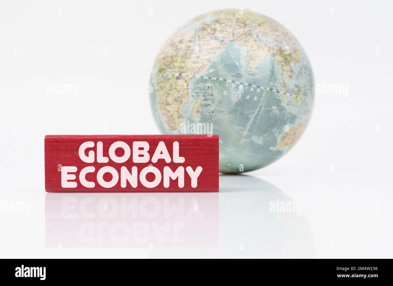 Concetto aziendale. Vicino al globo è una targa rossa con l'iscrizione - economia globale Foto Stock
