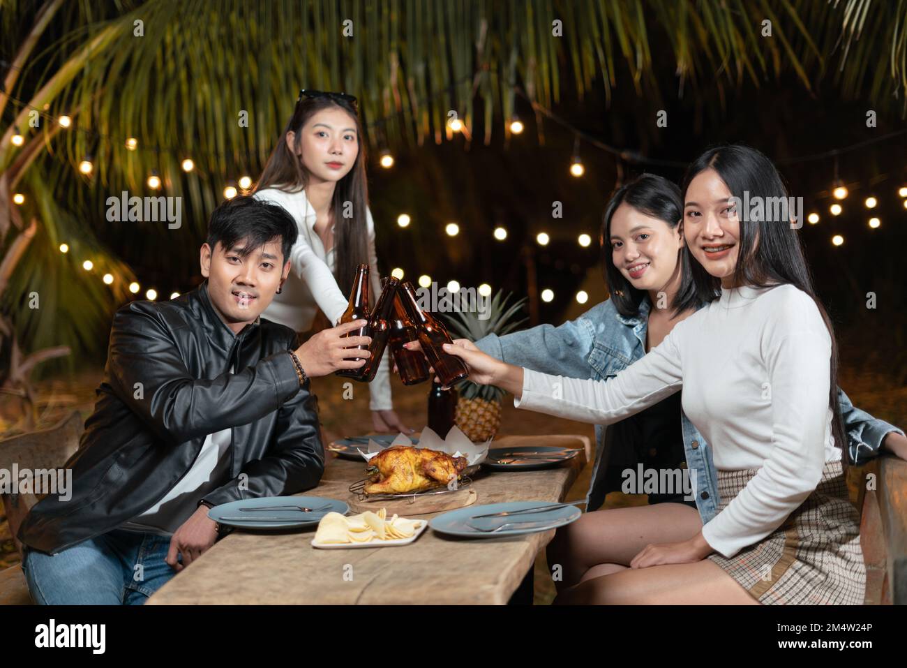 Gruppo di amici che bevono birra festeggiano la festa nel cortile Foto Stock