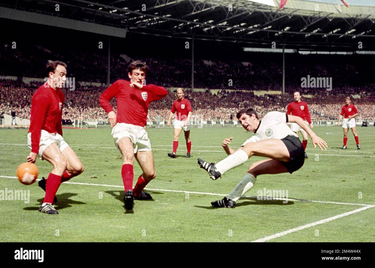 Foto del file datata 30-07-1966 dell'Inghilterra e della Germania occidentale in azione durante la finale della Coppa del mondo 1966 a Wembley a Londra. George Cohen, Martin Peters d'Inghilterra e Emmerich della Germania occidentale. L'ex difensore dell'Inghilterra e di Fulham George Cohen è morto all'età di 83 anni. Data di emissione: Venerdì 23 dicembre 2022. Foto Stock
