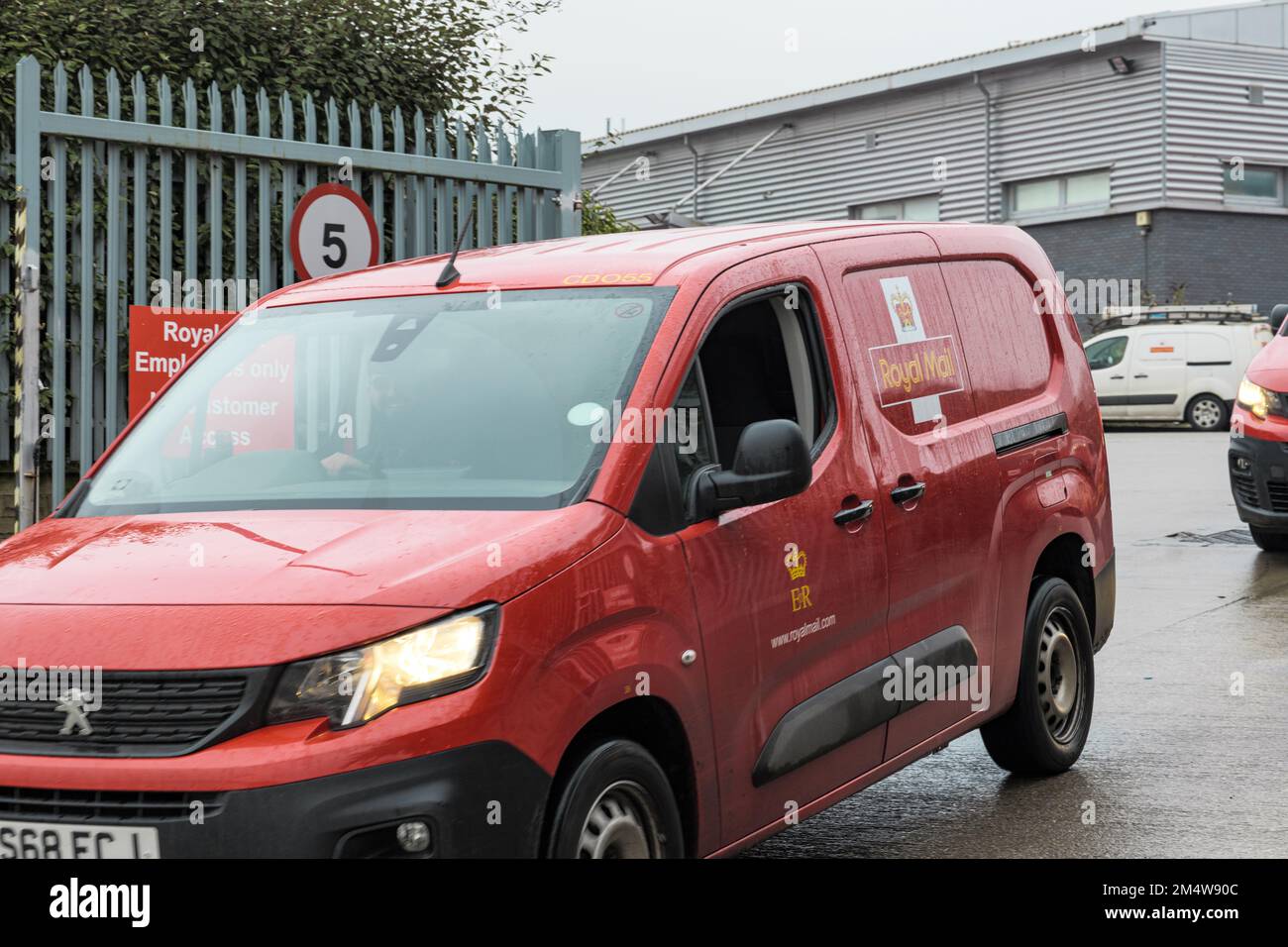 Bradford, Regno Unito. 23rd dicembre 2022. Un piccolo gruppo di spiccati postini e operatori postali si trova sulla linea del picket fuori dal North Bradford Royal Mail Delivery Centre. Le consegne continuano ad essere effettuate nonostante l'azione industriale dell'Unione dei lavoratori della comunicazione, ma un gran numero di furgoni di consegna rimangono inutilizzati presso il deposito del centro postale. Credit: Bradley Taylor / Alamy News Foto Stock