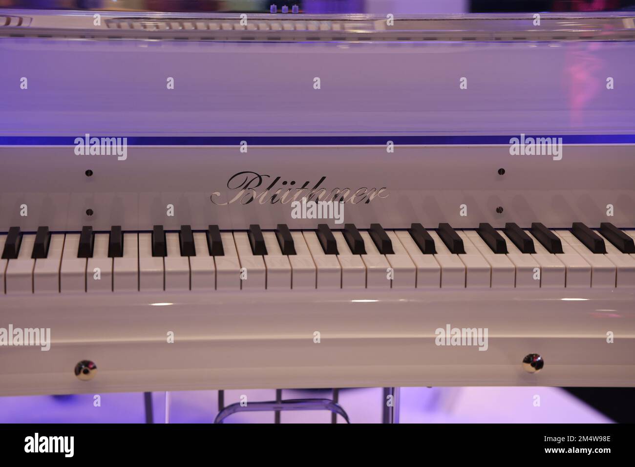 Tastiera di un pianoforte a coda bianca con marchio visibile: Blüthner Foto Stock