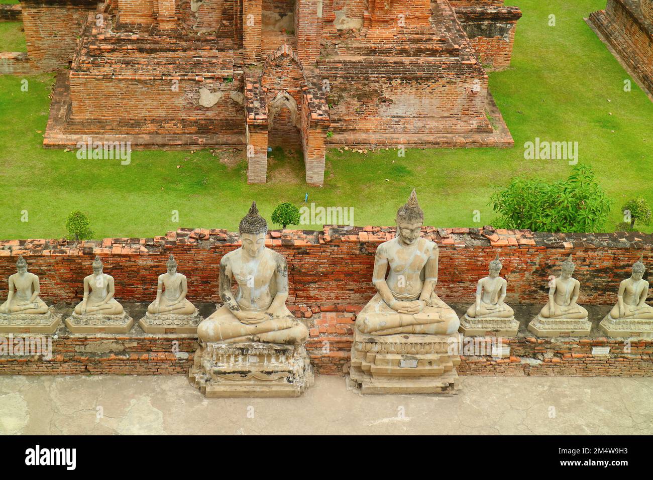 Impressionante veduta aerea della fila di immagini di Buddha seduto al Tempio di Wat Yai Chai Mongkhon nel Parco storico di Ayutthaya, Thailandia Foto Stock