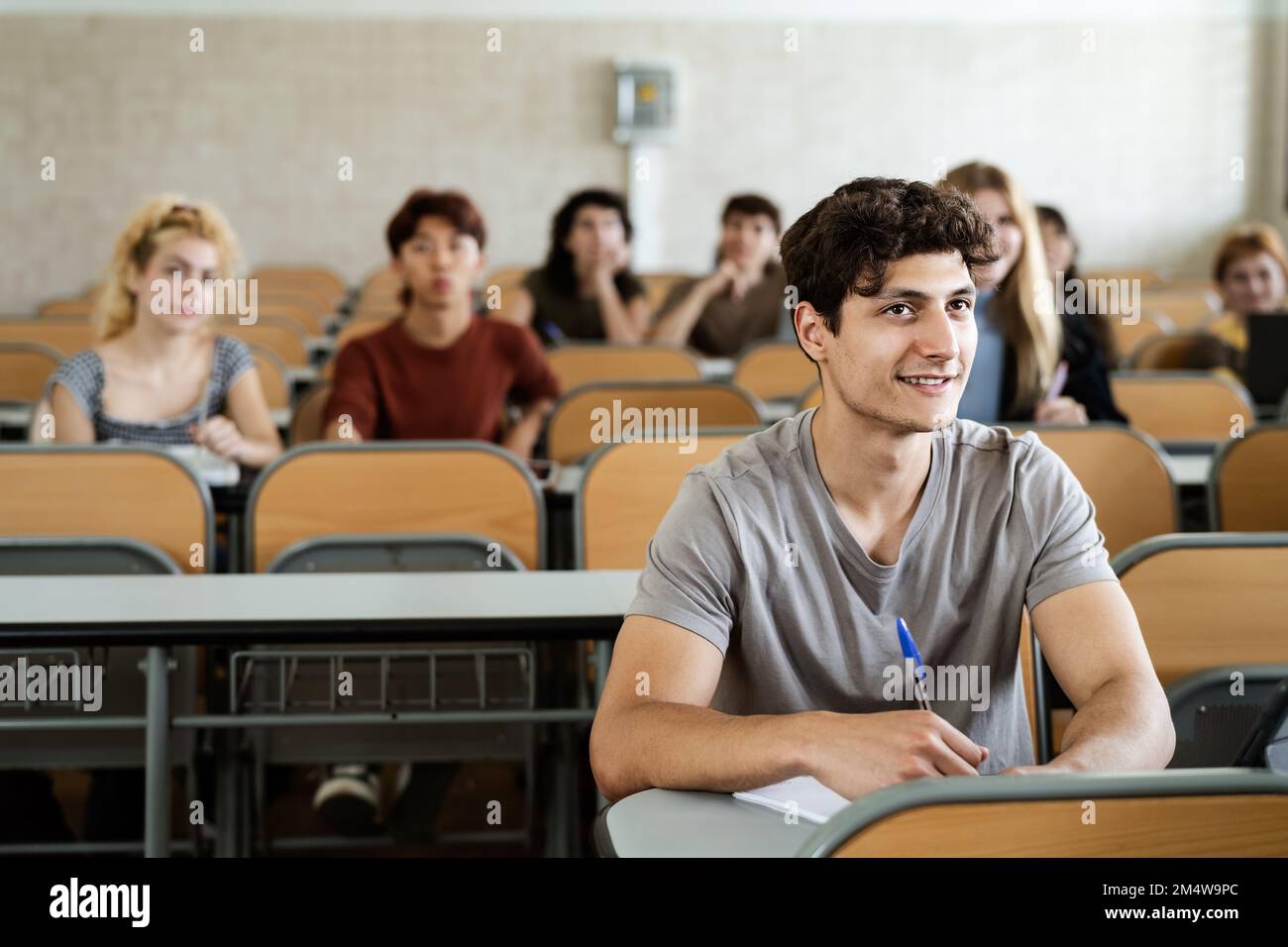 Giovani studenti che ascoltano la lezione all'interno della classe universitaria - concetto di educazione scolastica Foto Stock