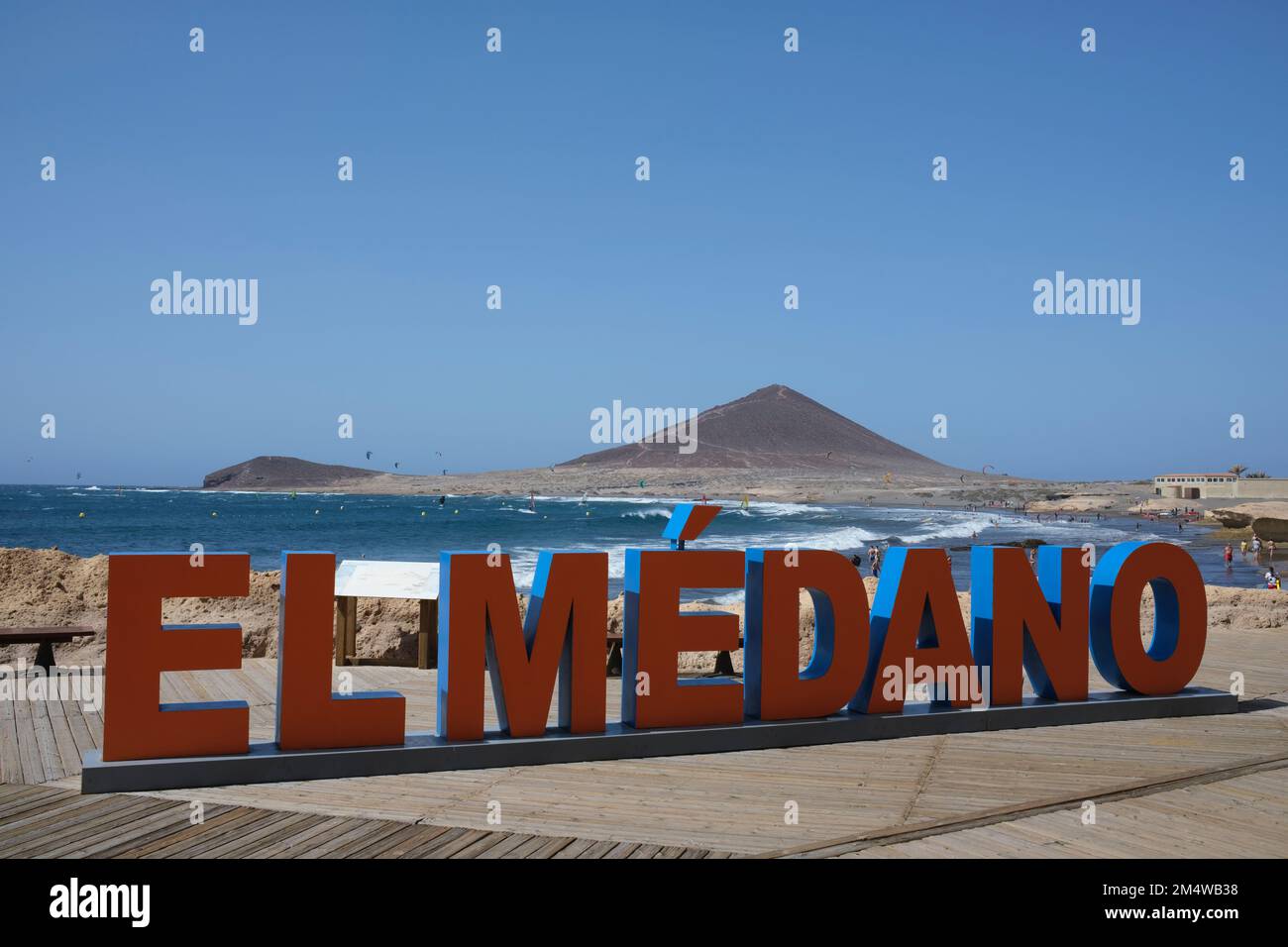 Le lettere giganti rosse e blu spiegano il nome della città costiera, El Medano, una mecca per i windsurf, i kitesurf e i vacanzieri che amano le acque Foto Stock