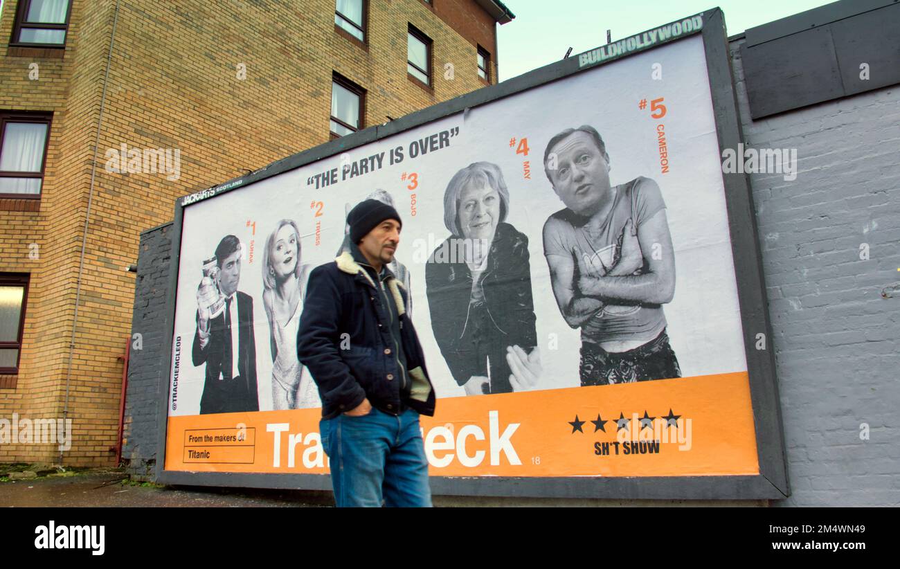 Glasgow, Scozia, Regno Unito 23rd dicembre 2022. Un nuovo cartellone satirico è apparso nell'estremità orientale di Glasgow, vicino al mercato di Barras. Un'immagine anti-governativa basata sul famoso poster del film di avvistamento dei treni. 'Trainwreck', l'opera d'arte è un nuovo manifesto di lingua in guancia dell'artista di Glasgow Trackie McLeod. Credit Gerard Ferry/Alamy Live News Foto Stock
