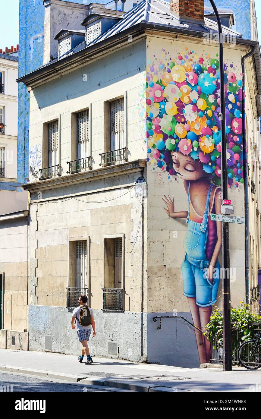 Uno dei più bei graffiti di Parigi : ragazza con i capelli comorful che guardano la gente che passa vicino sulla strada. Foto Stock