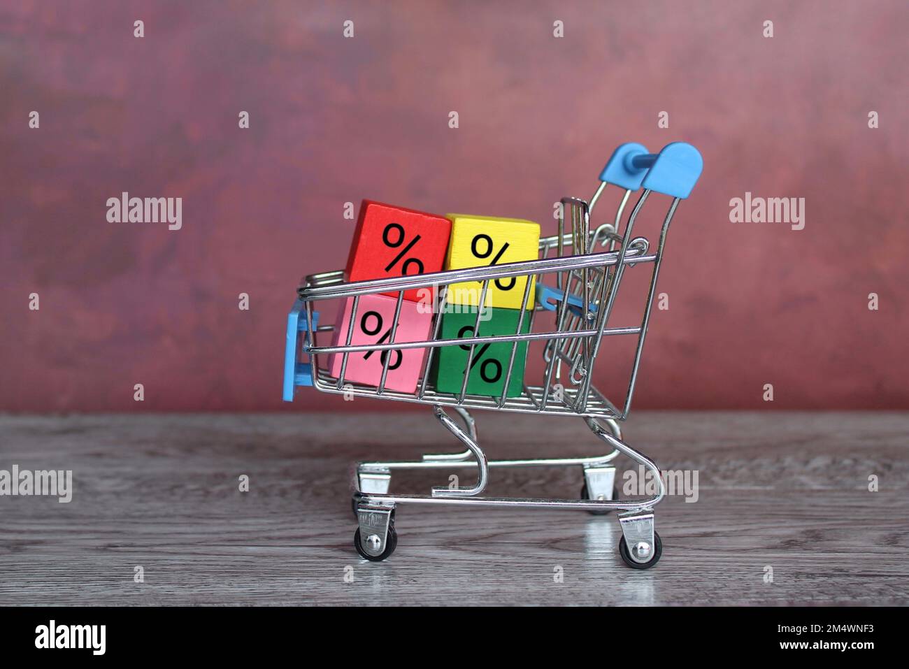 Carrello per lo shopping e blocchi colorati con segno di percentuale. Shopping, sconti, cashback, vendita concetto Foto Stock