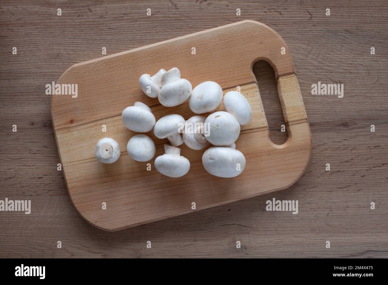 Champignons fresco su una tavola di legno sul tavolo. Vista dall'alto di verdure fresche per cucinare. Foto Stock