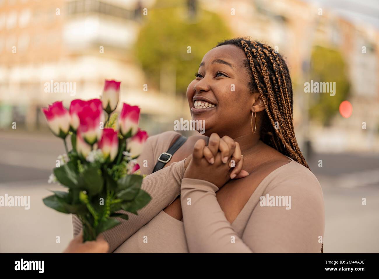 Felice giovane donna con l'uomo che dà bouquet di fiori Foto Stock