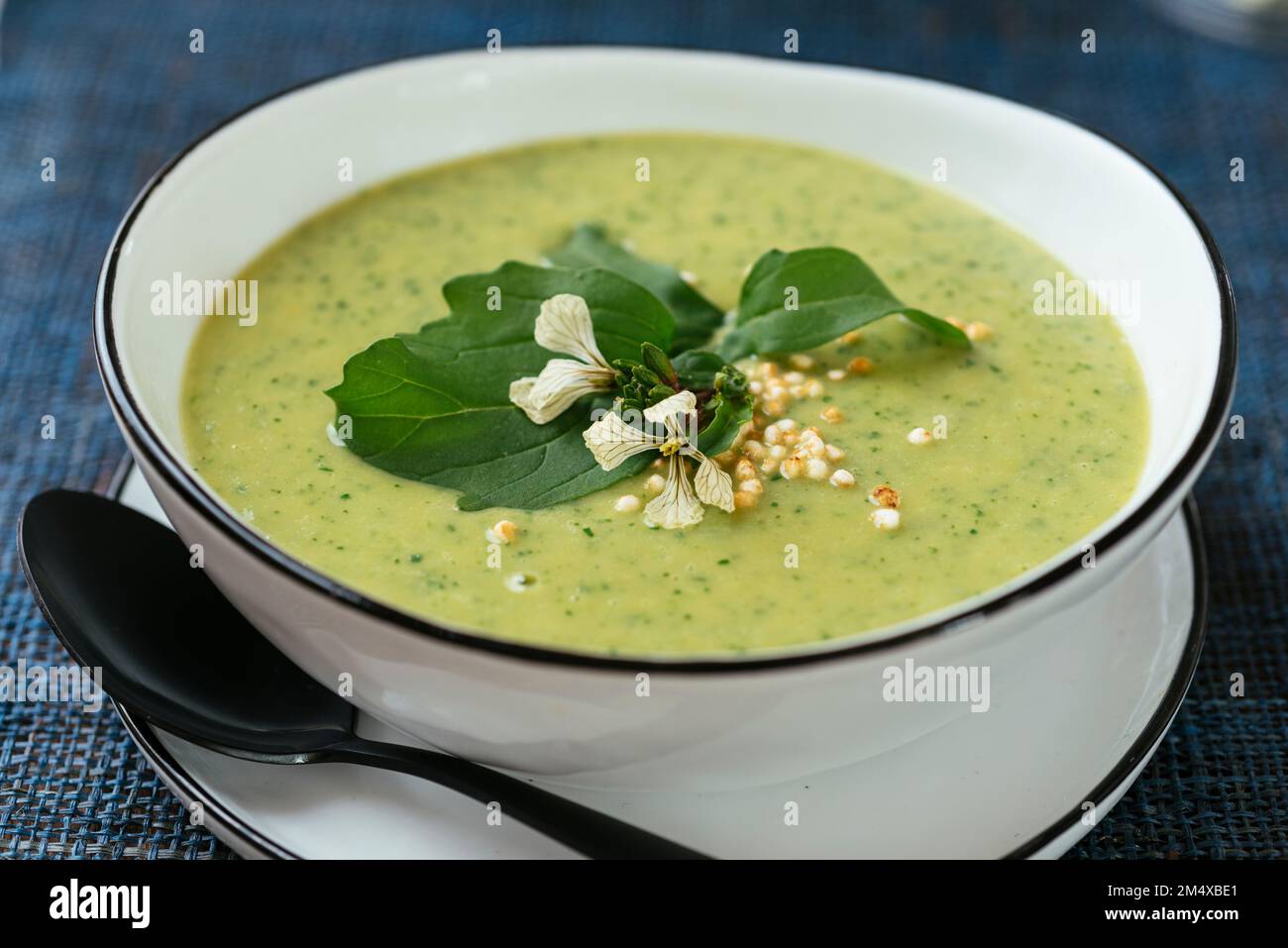 Zuppa di broccoli e rucola fatta in casa, guarnita con quinoa soffiata. Foto Stock